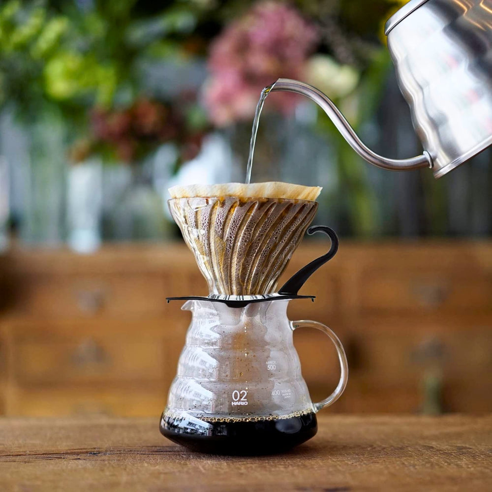 Brewing coffee on a Hario V60 black glass dripper